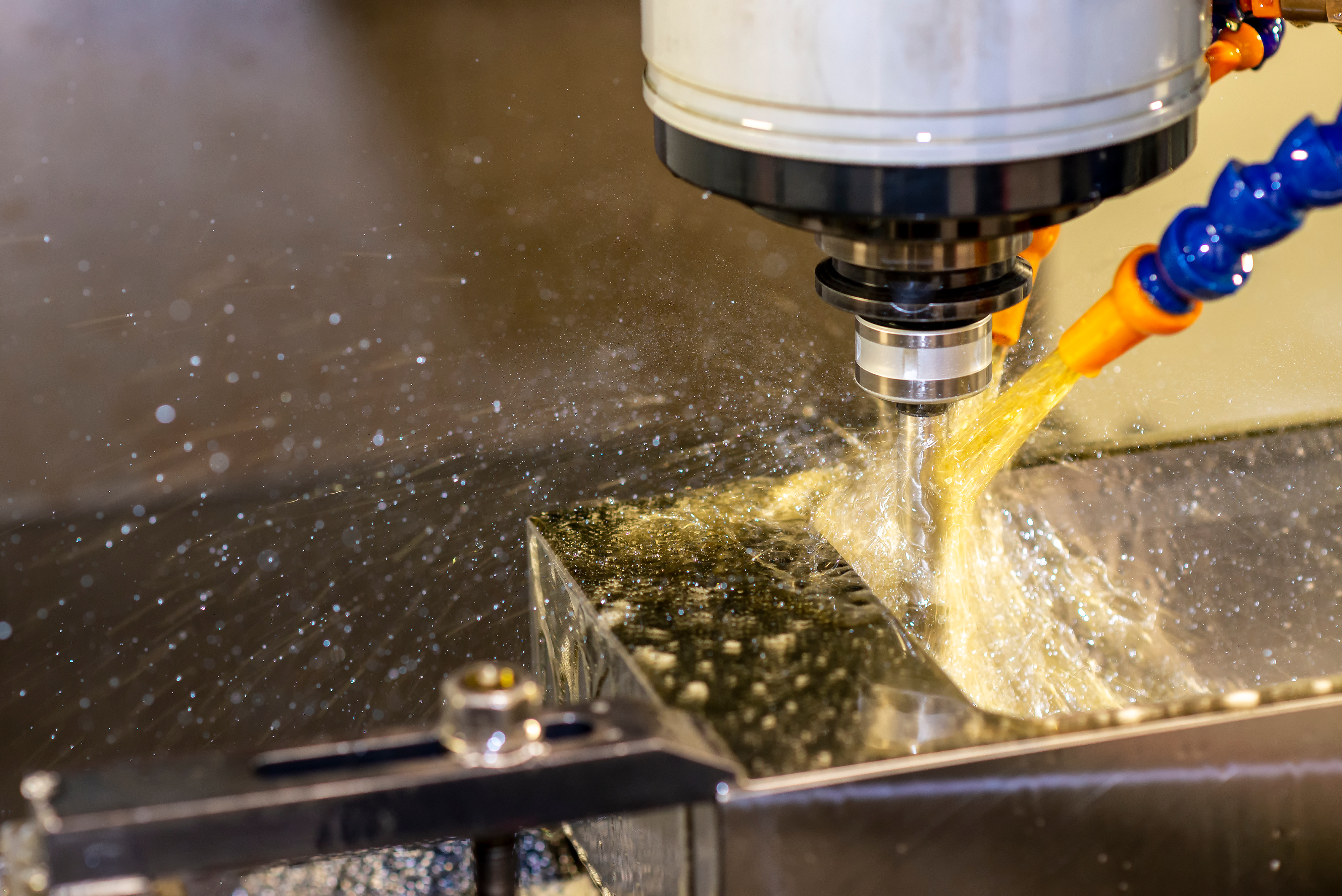 The CNC milling machine cutting the injection mould parts with the oil coolant method.