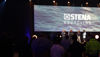 a stage with people and a wide background