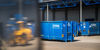 Blue containers and the reflection of a truck