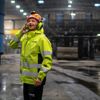 Man i varselkläder i produktionsmiljö