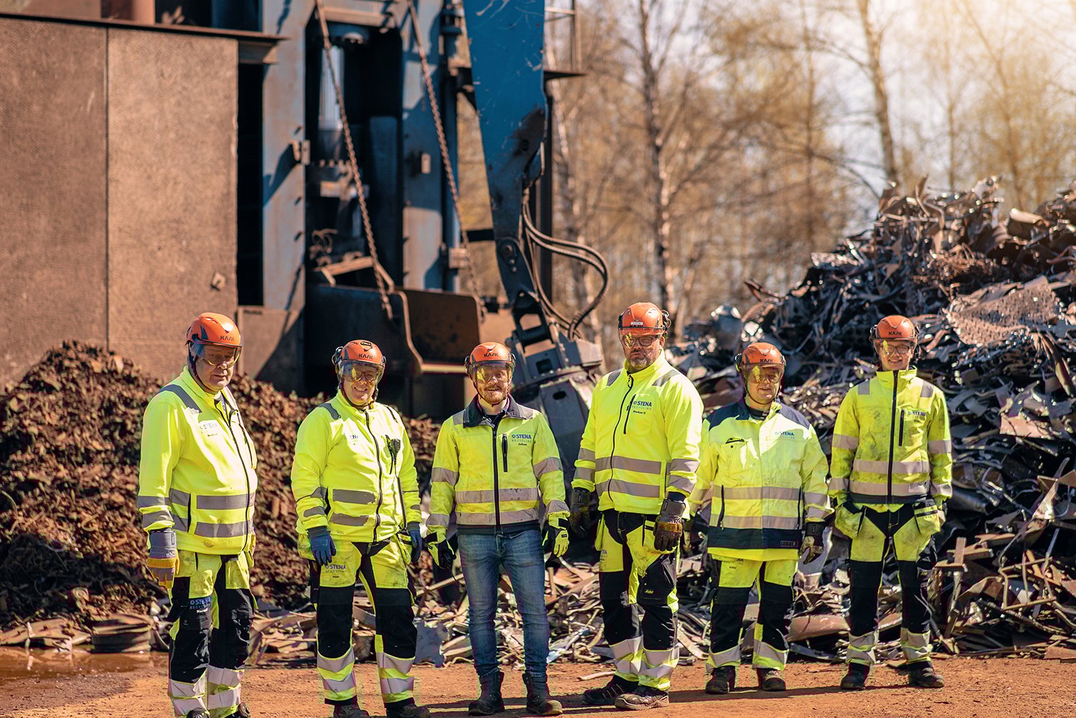 Grupp av medarbetare i varselkläder utomhus på filial