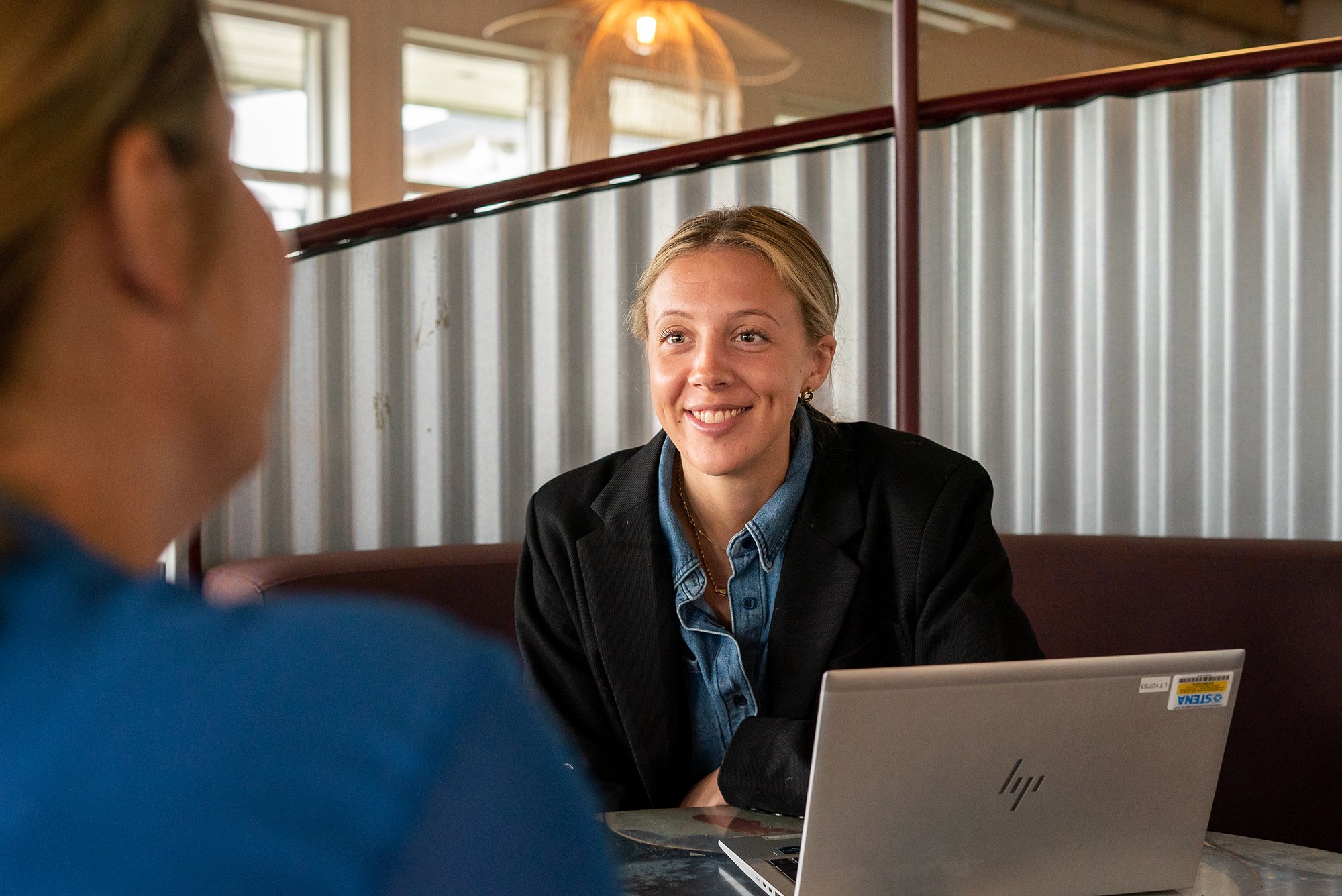 Ung leende kvinna med laptop