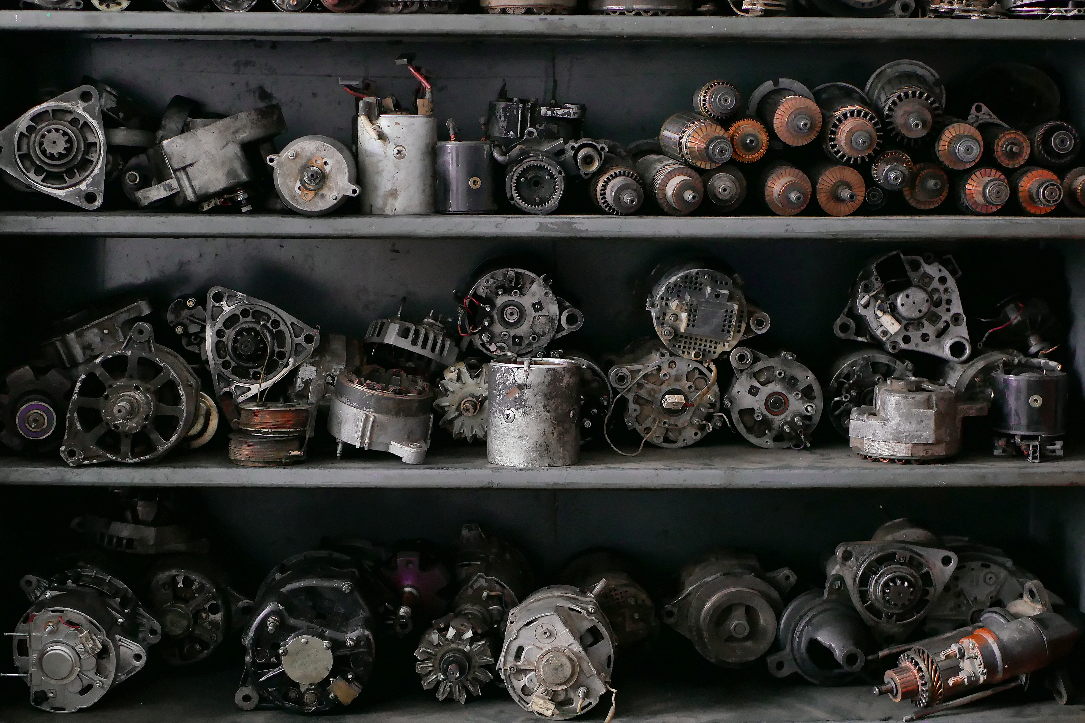 A shelf displaying an assortment of vintage motors and various mechanical parts.