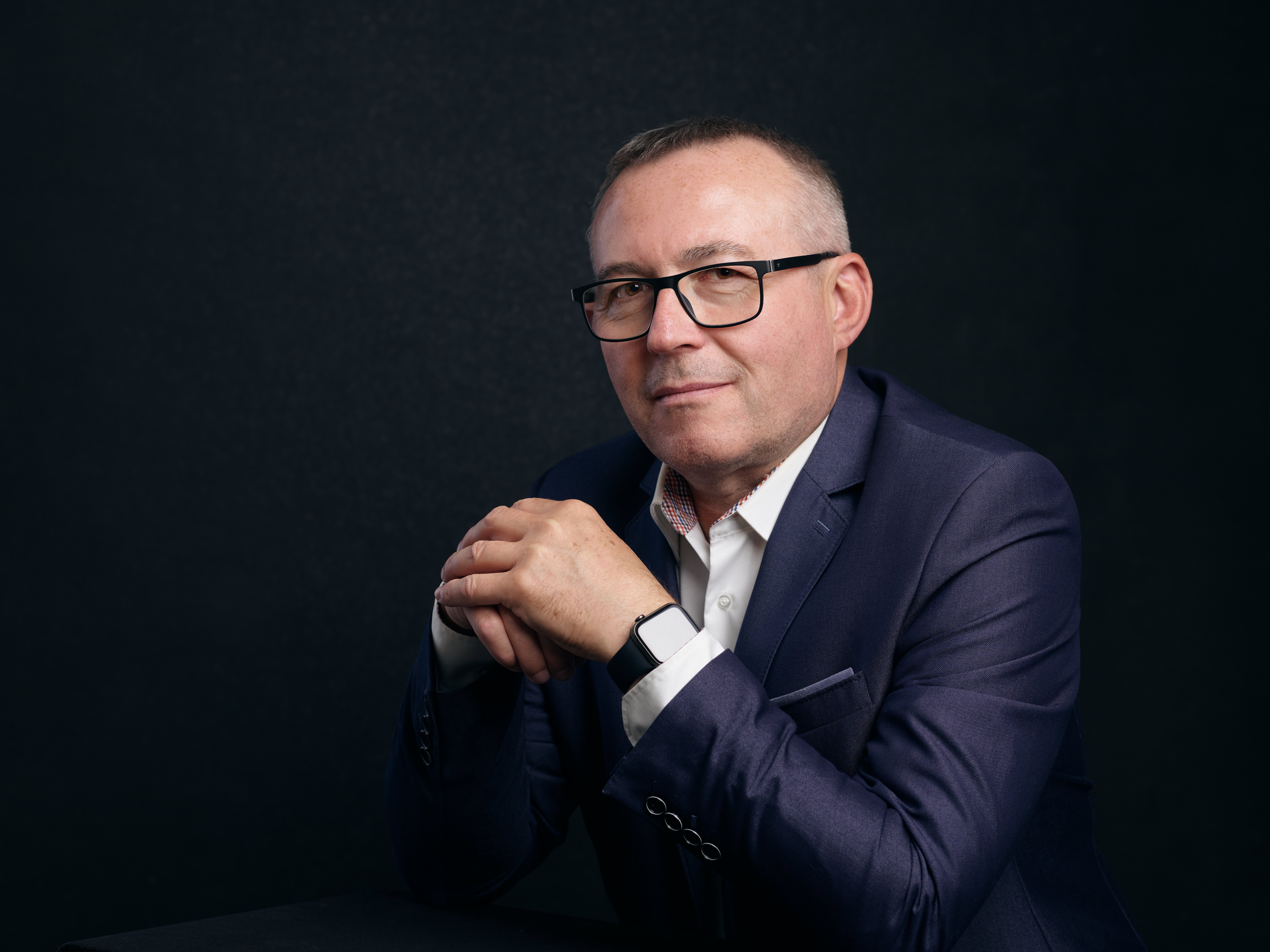 Mężczyzna w garniturze na czarnym tle