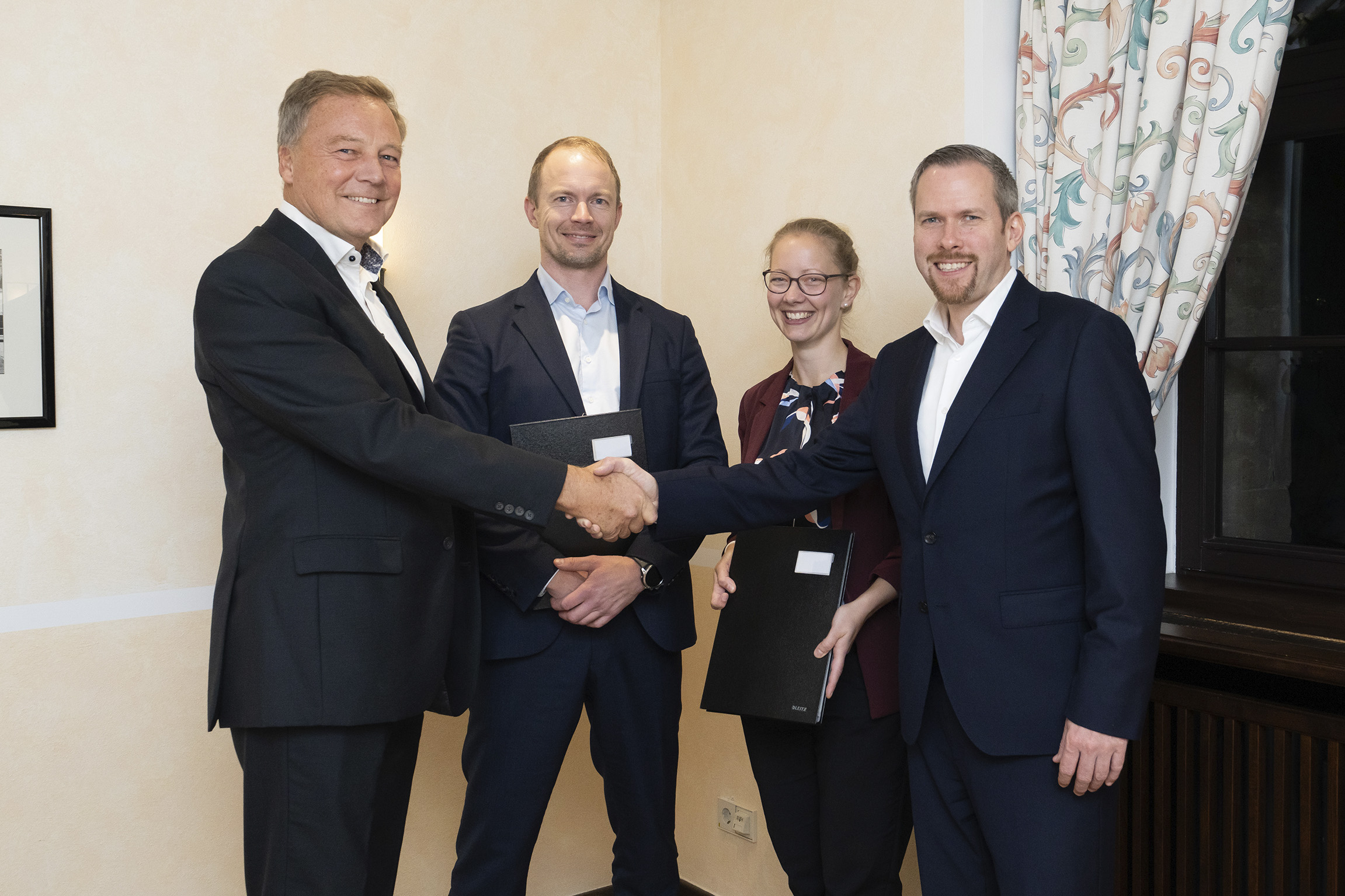 Fire personer som håndhilser: Mats Berneblad, Marcus Martinsson, Dr. Birgit Gerke, Dr. Daniel Schönfelder.