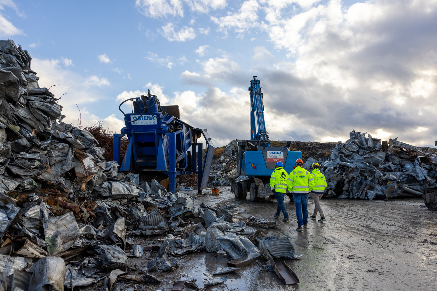 men walking amongst scrap metal