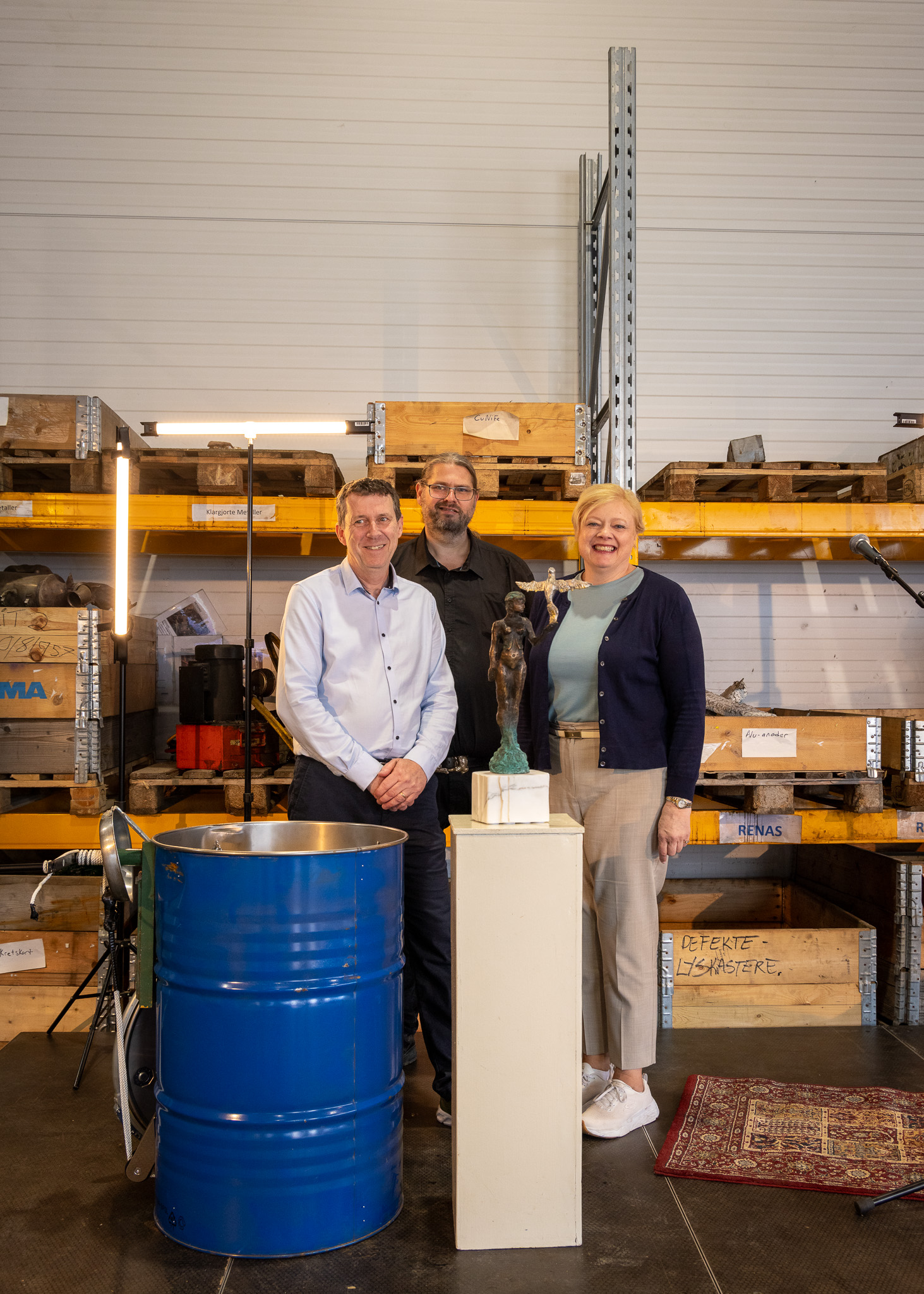 three people behind a sculpture