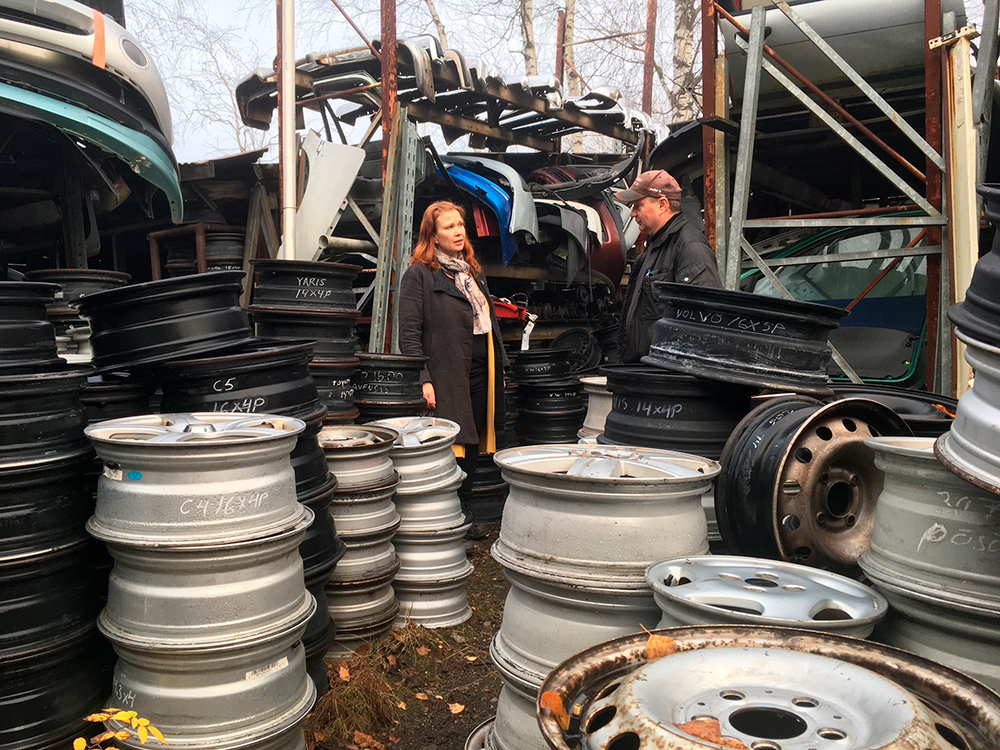 Autopurkamon pihassa romuautojen vanteita ja purkuosia