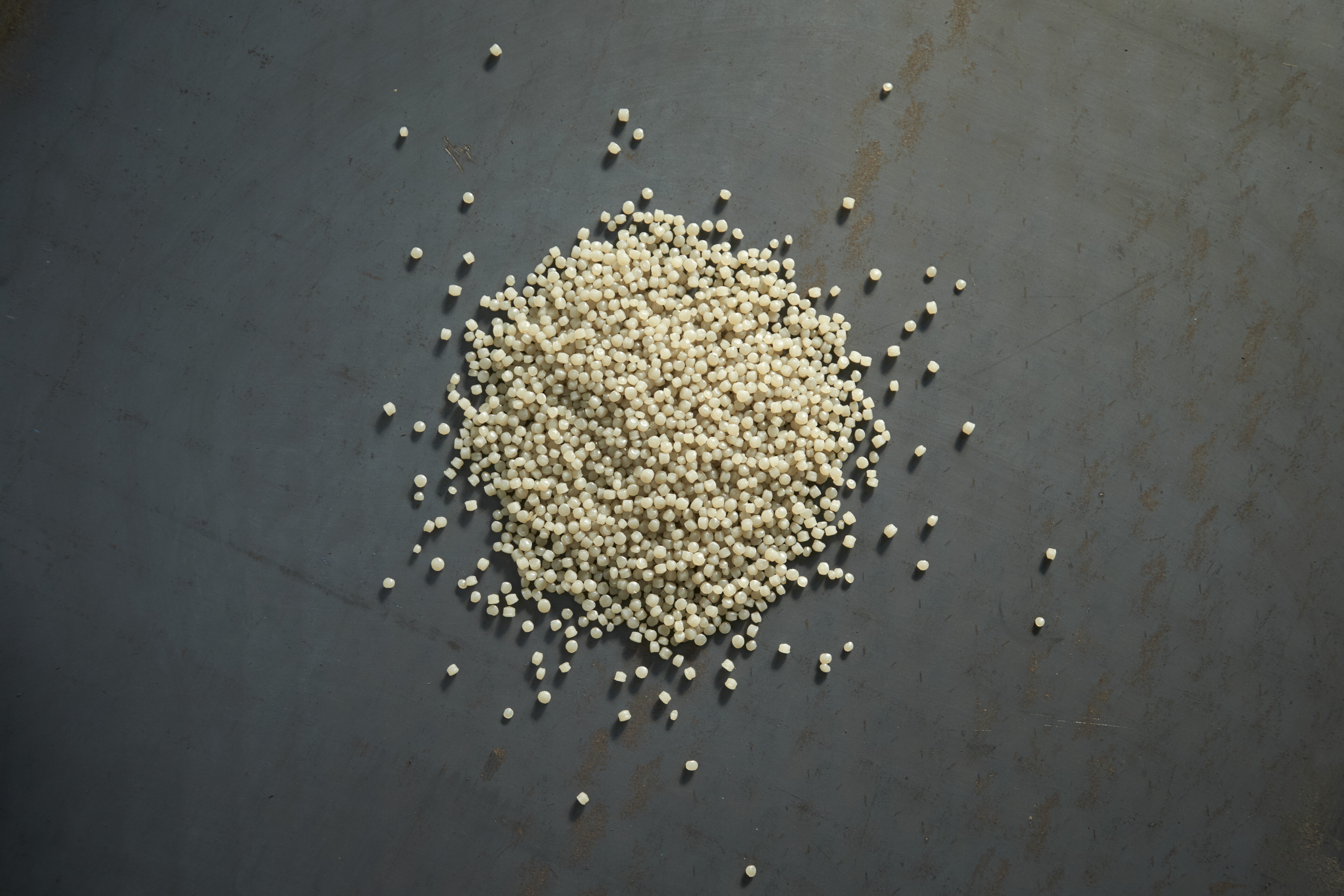 Zdjęcie jasnego regranulatu na ciemnej powierzchni