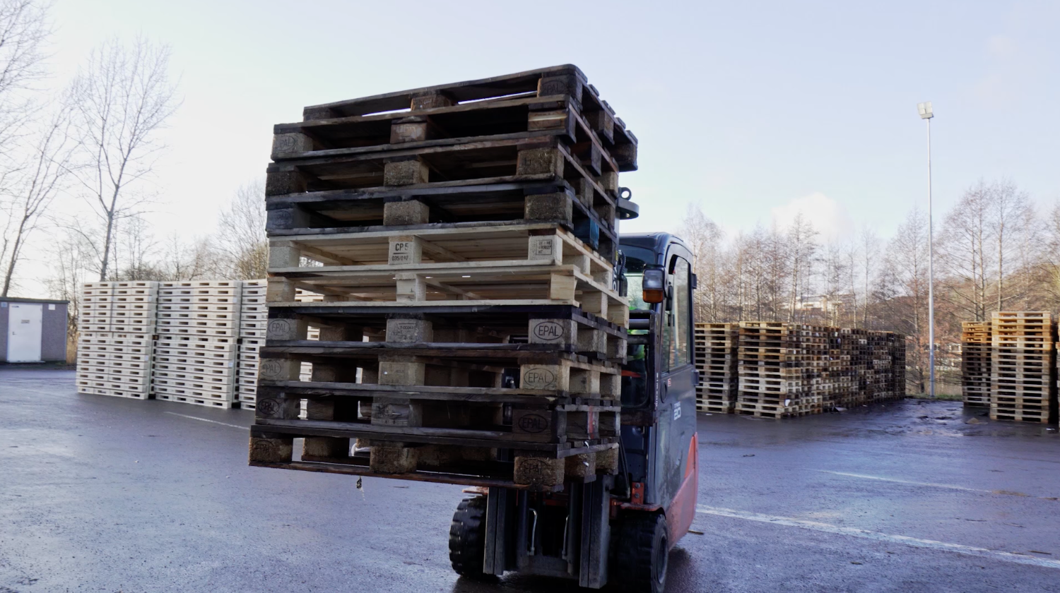 Hjullastare lyfter träpallar