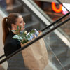 Kobieta na schodach ruchomych z torbą na zakupy