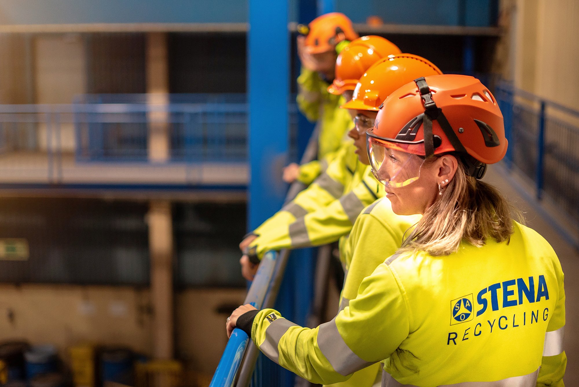 A close up image of four Stena Recycling workers in protective clothing standing together in Stena Nordic Recycling Center