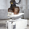 A material handler claw lifting parts of an old refrigerator