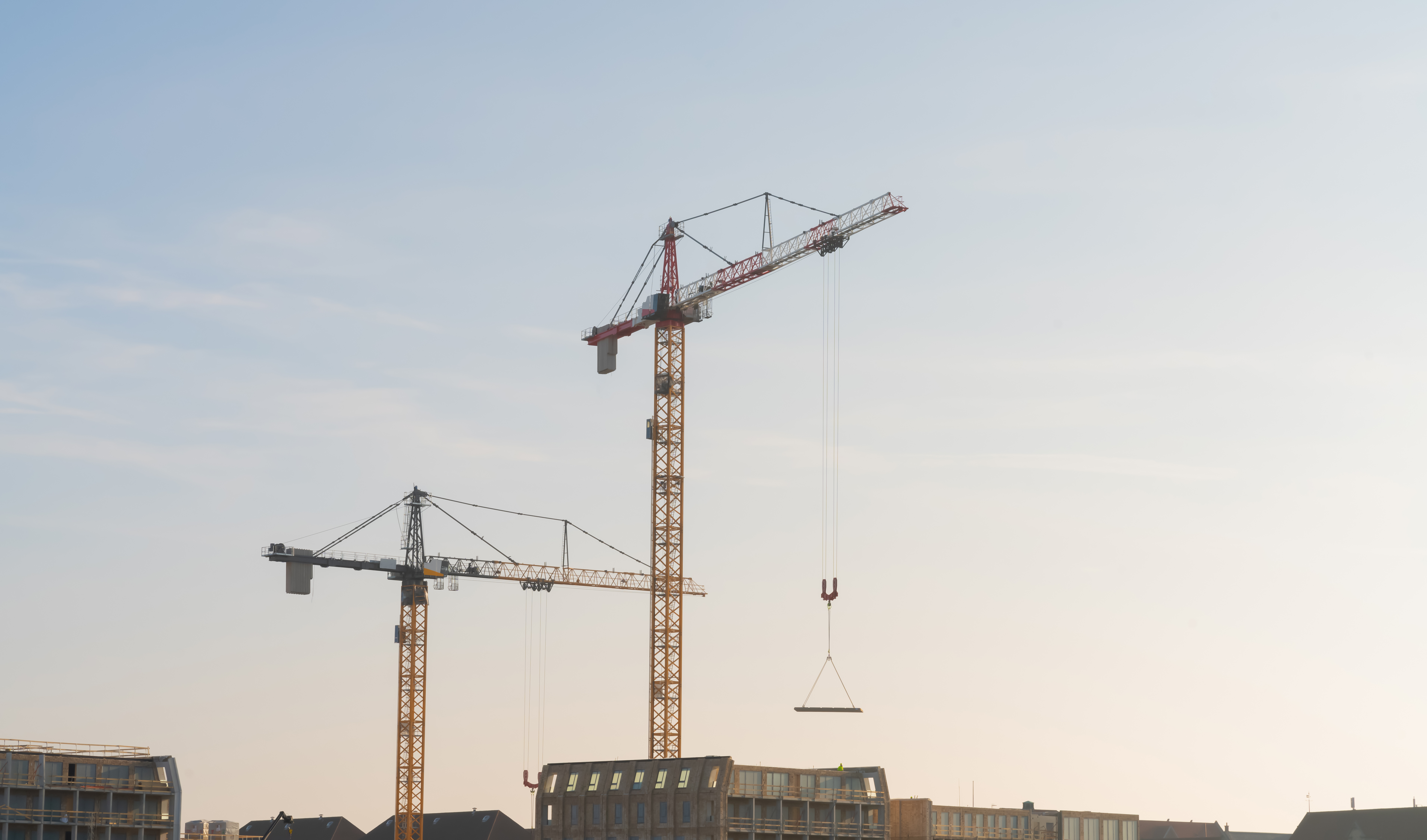 Silhouette of construction workers on top of a scaffolding, casting a concrete pillar