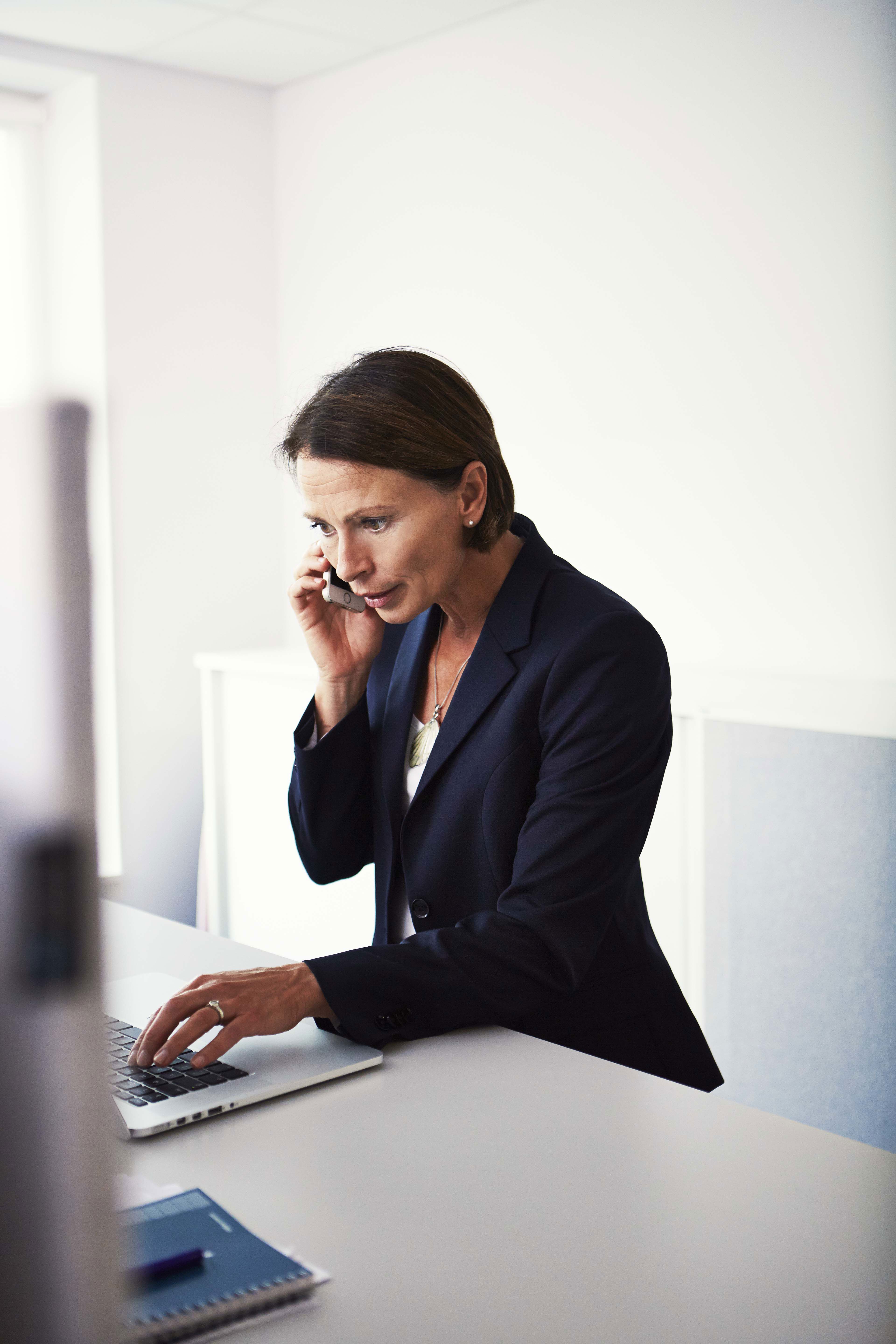 Zbliżenie dłoni pracownika Stena Recycling pracującego przy laptopie w biurze.