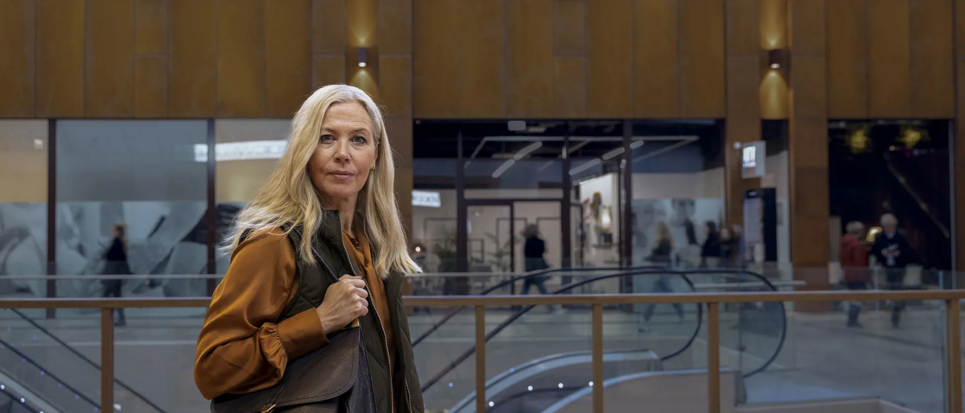 Nainen ostoskeskuksessa katsoo suoraan kameraan