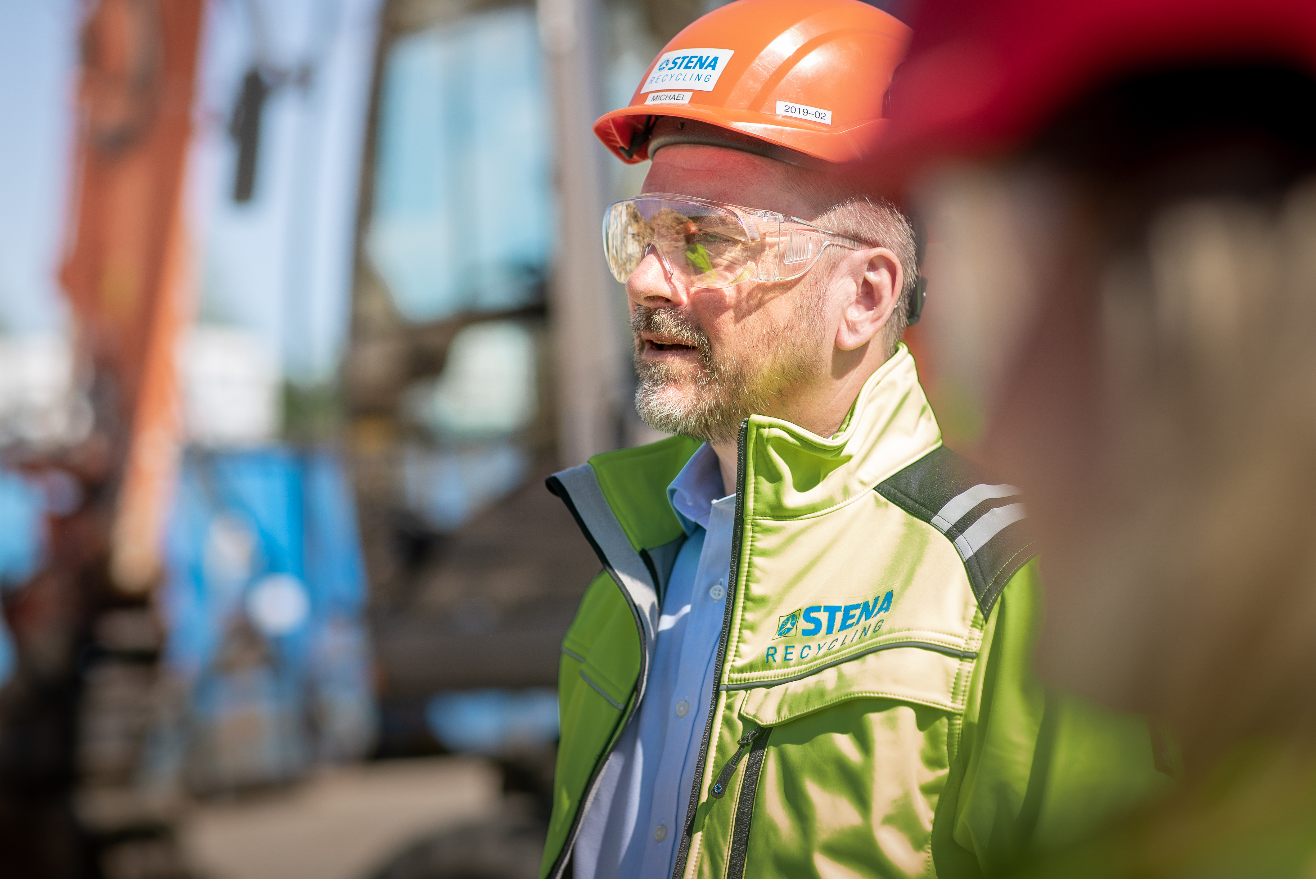 En expert på Stena Recycling klädd i reflekterande arbetskläder, hjälm och skyddsglasögon.