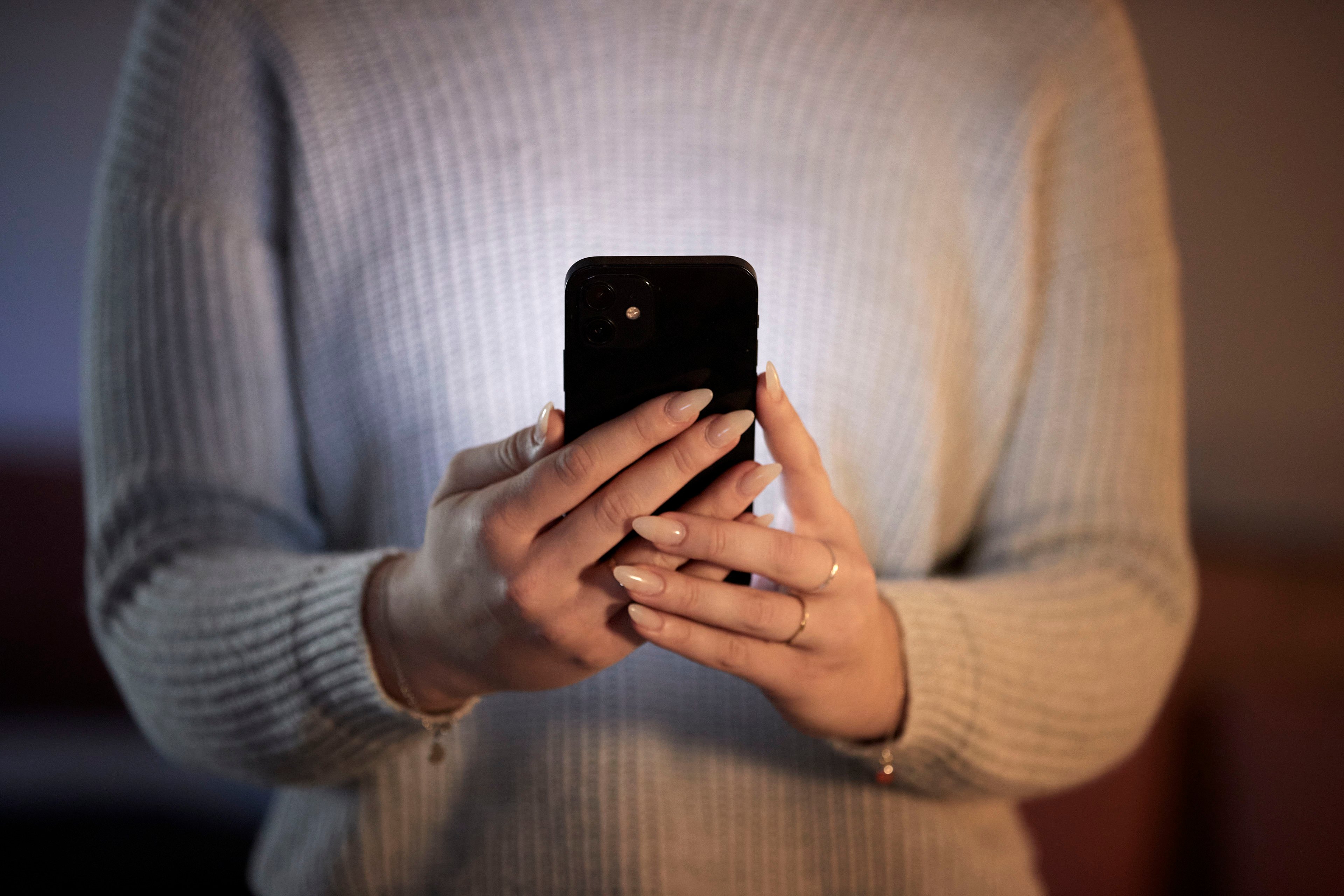 A person holding a mobile phone and texting