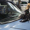 A mechanic dismantles an end-of-life vehicle.