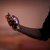 Et nærbillede af en hånd, der holder en mobiltelefon, mens lyset skinner fra telefonens skærm