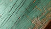 Close-up of a worn, green-painted piece of waste wood ready for recycling