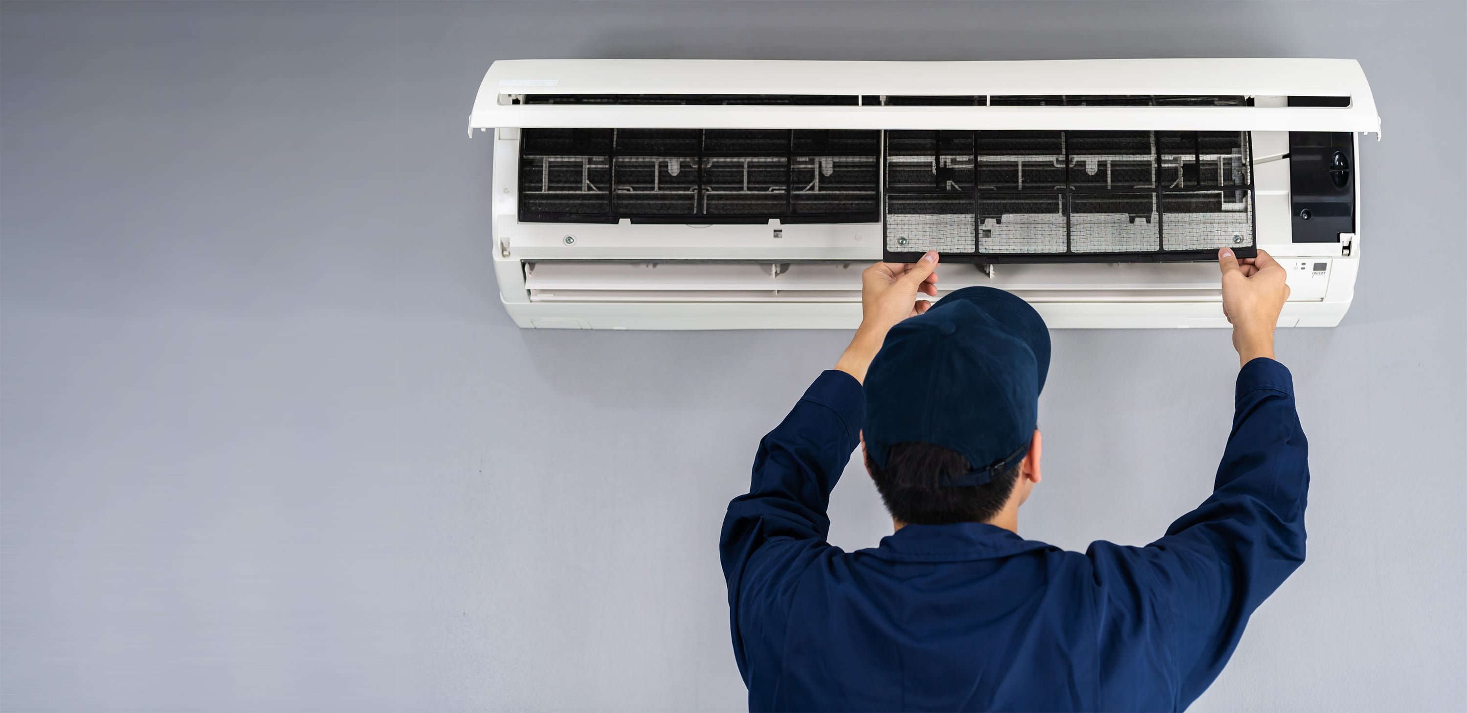 A man working to repair an air conditioning unit.