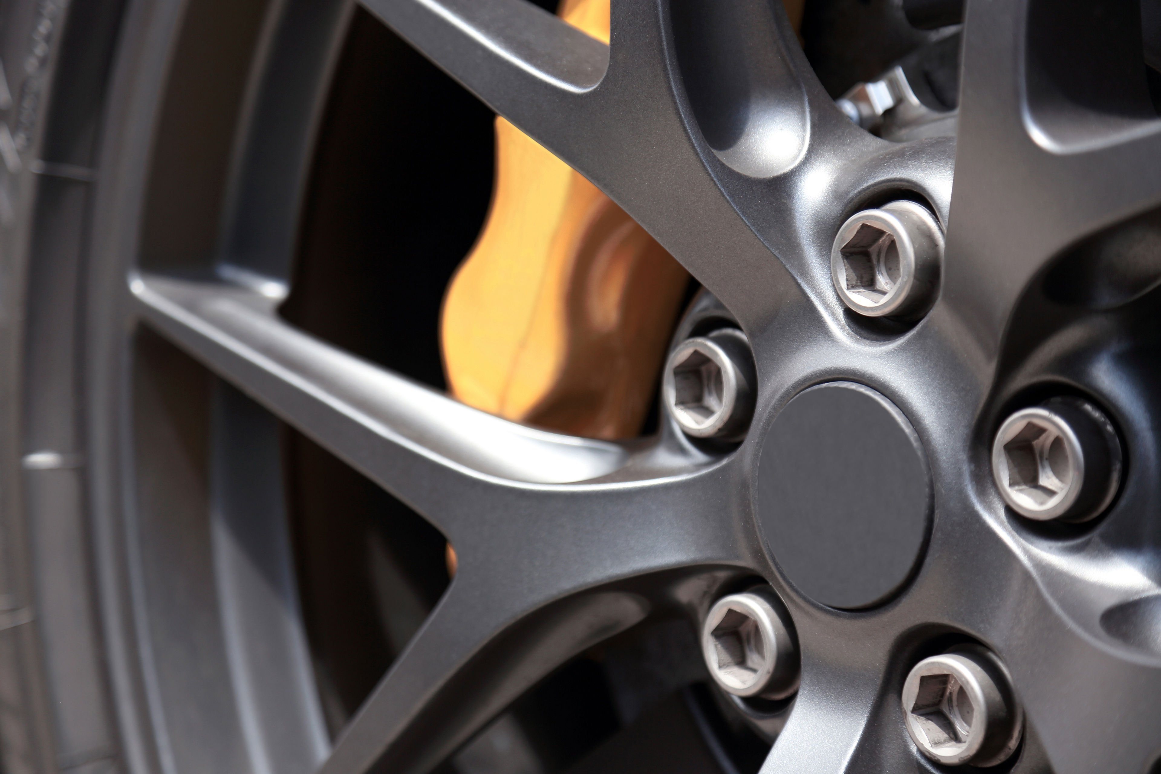 Close-up of a grey alloy wheel covering a yellow brake caliper