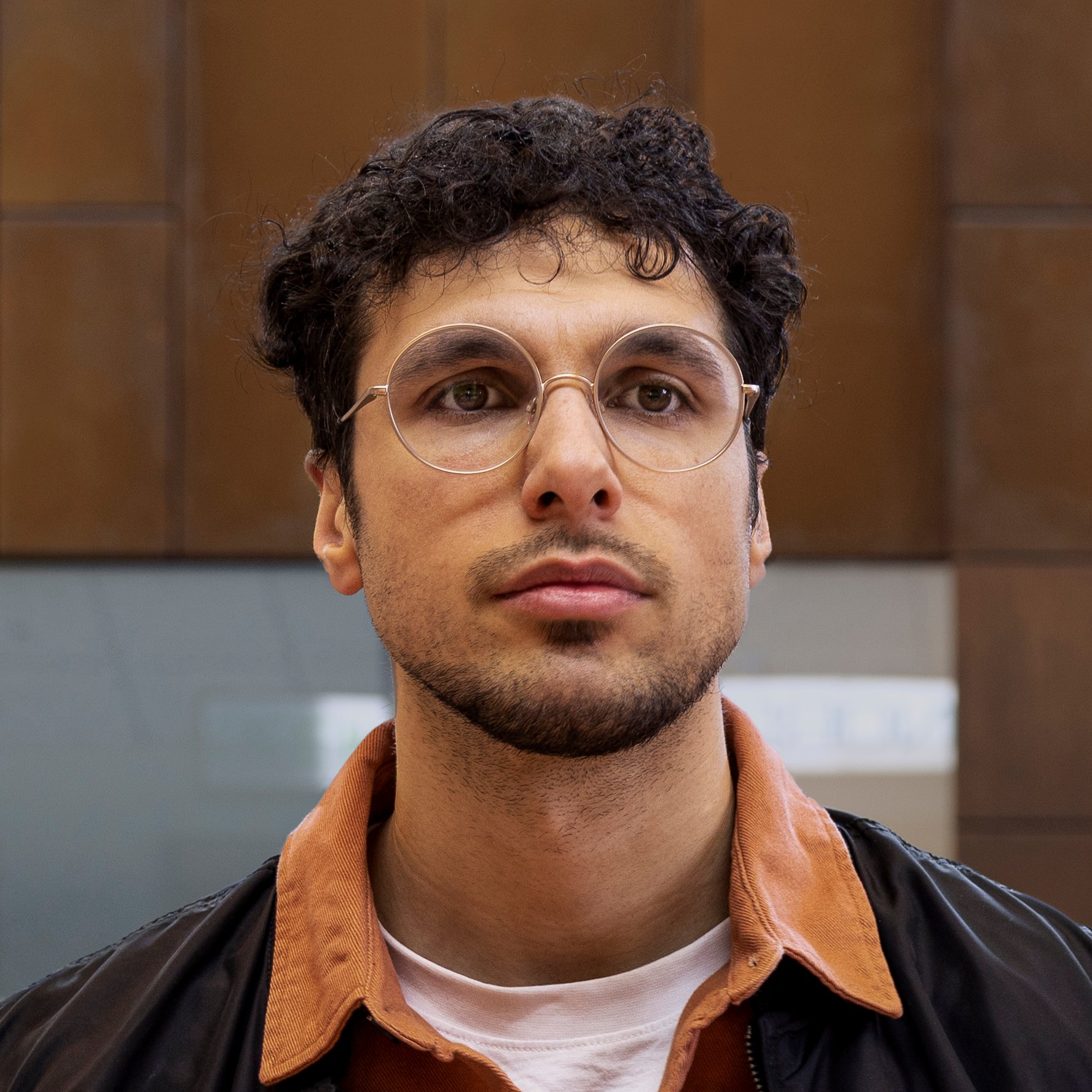 Mies kauppakeskuksessa katsoo kohti kameraa