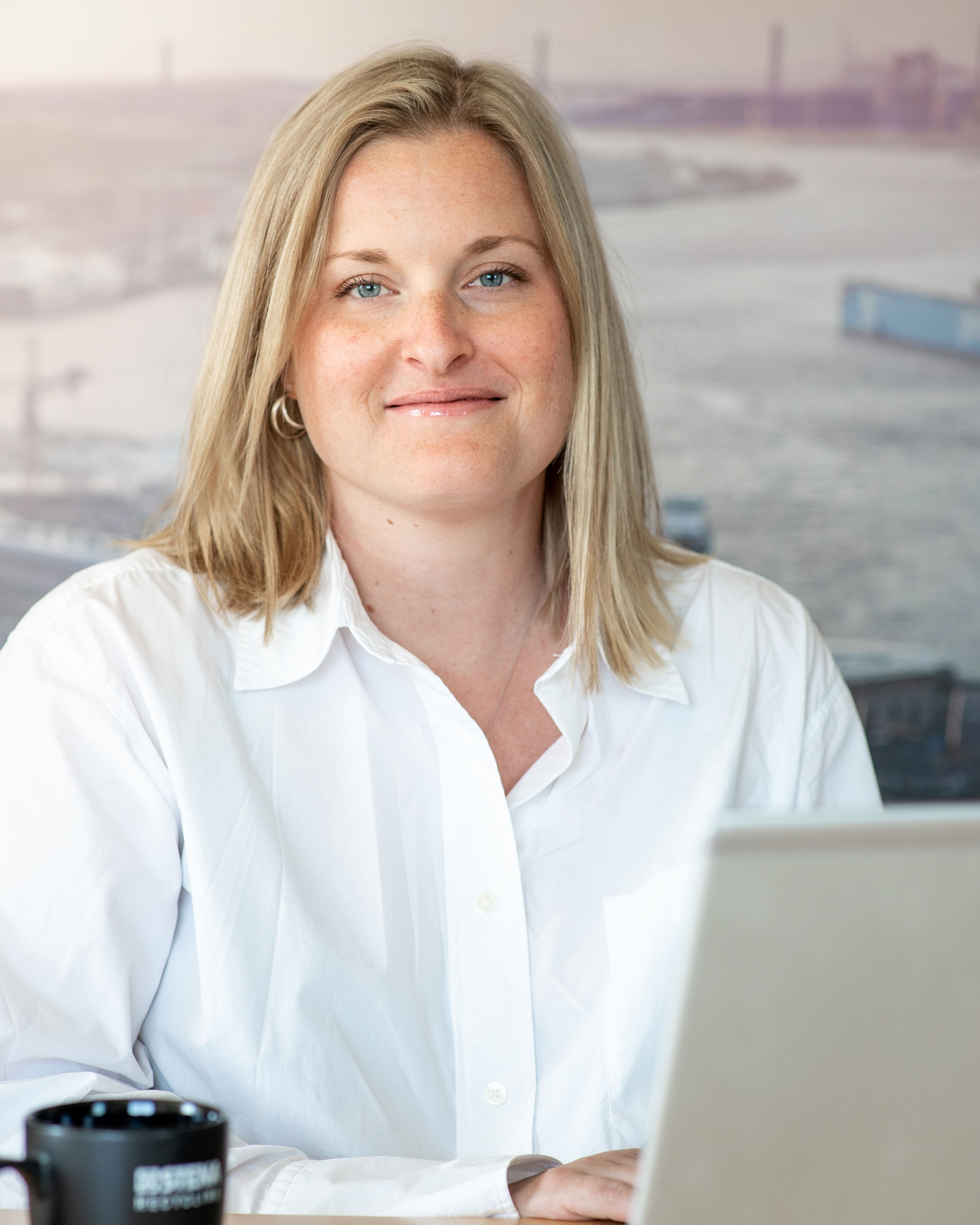 A female Stena Recycling employee wearing a white shirt with Gothenburg – home of Stena Recycling – in the background.